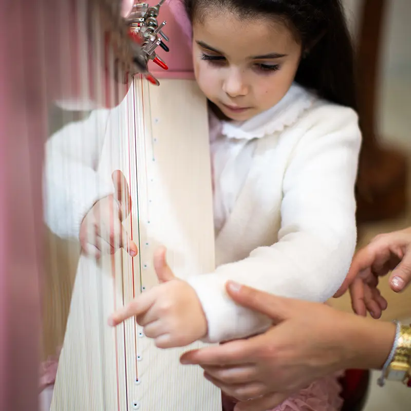 Bambina impara a suonare l'arpa con il corso Prime Note Arpeggiando Scuola di Musica Suzuki per bambini